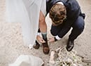 groom fixing his bride's shoes- Dolomites Elopement