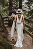 bride and groom walking featuring back bridal detail- Dolomites Elopement