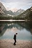 groom walking down the lake of Dolomites- Dolomites Elopement 