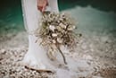 bride holding her bridal floral while standing- Dolomites Elopement