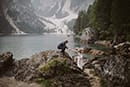 groom helping bride to climb the big rock in Dolomites- Dolomites Elopement