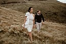 bride and groom walking in the mountains while cold breeze pass them- Queenstown Wedding 