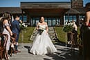bride walking down the aisle as the guests greet her- Queenstown Wedding