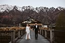 bride and groom elegantly standing in the middle of the beautiful house view- Queenstown Wedding