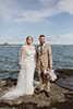 bride and groom standing in rocky sea ground- Taupo Wedding