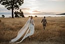 bride and groom walking towards the sun as it starts to set- Taupo Wedding