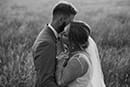 bride and groom lovingly hugging in the middle of tall grass- Taupo Wedding